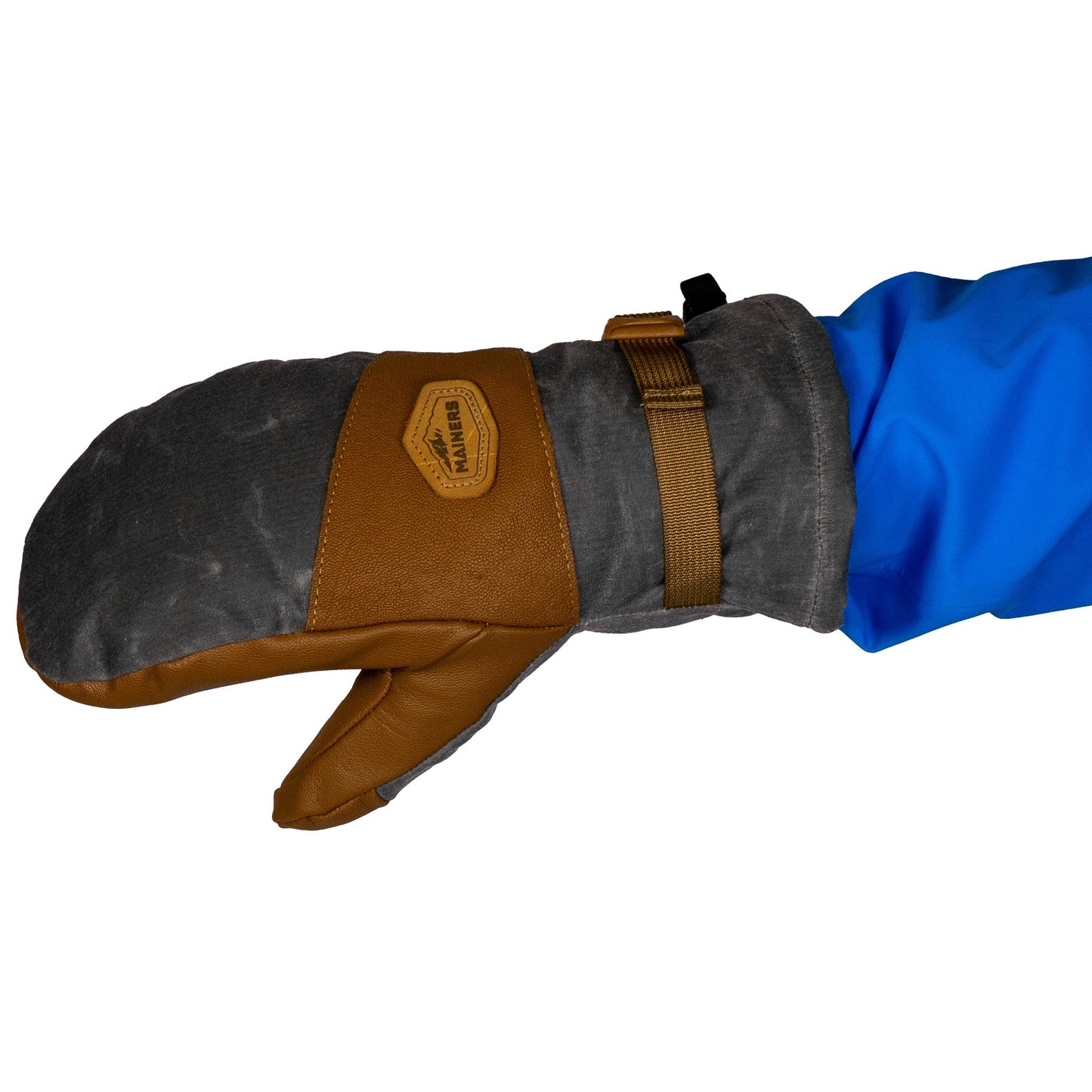 Close-up of the Mainers Acadia Mitts, highlighting their gray and brown design with a leather accent and strap, worn on an arm in a blue sleeve. Crafted from waxed canvas, they provide warmth and comfort ideal for chilly days.