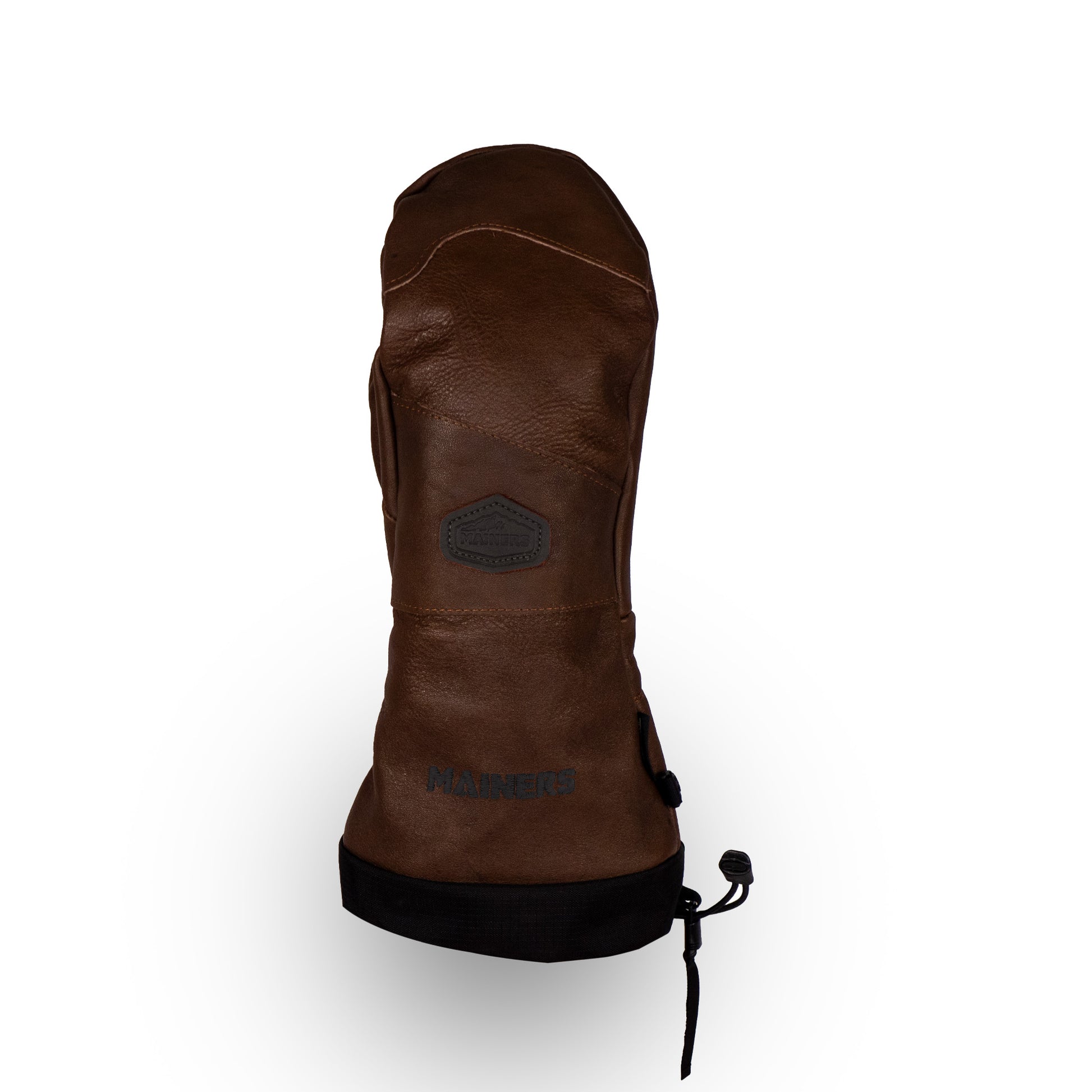 Introducing the Mainers All-Leather Mitts, featuring a brown all-leather design with a black adjustable strap and a hexagonal logo patch on the back. Known for their extreme wind resistance, these mittens have the brand name "Mainers" embossed near the bottom and are proudly made in the USA.