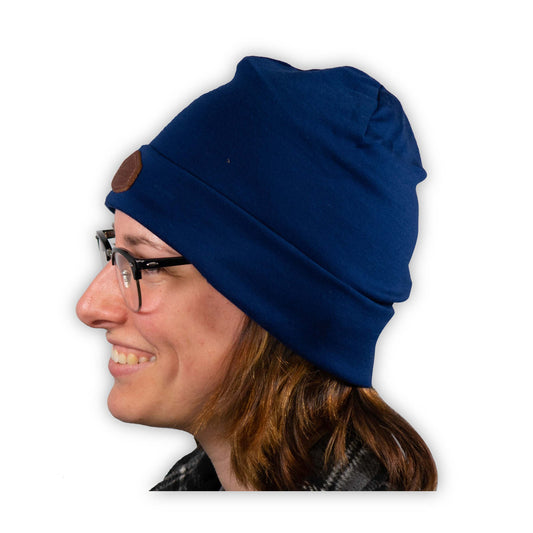 A woman wearing a blue Mainers Lightweight Wool Beanie with a leather patch.