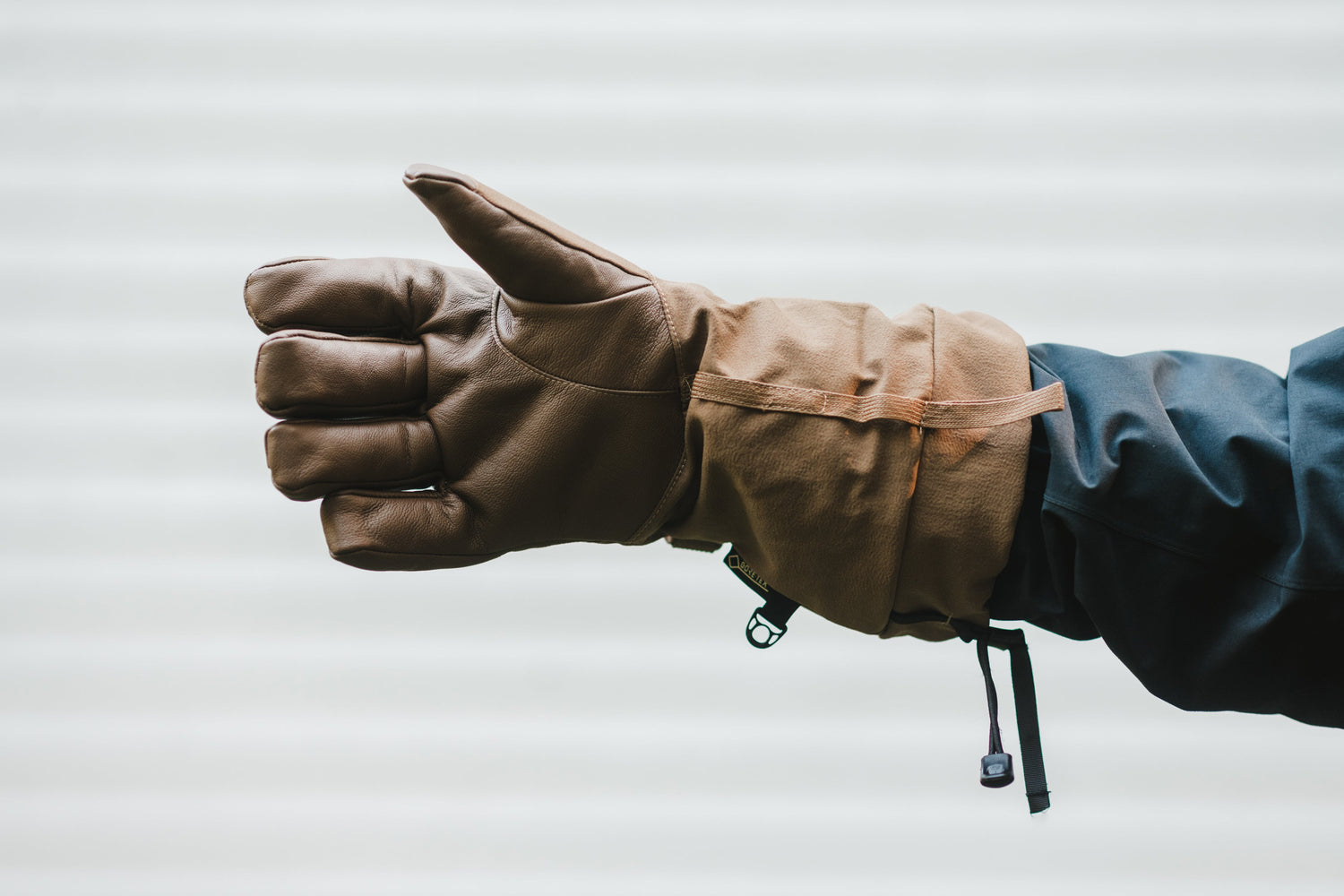 A person giving a thumbs up in a pair of gloves.