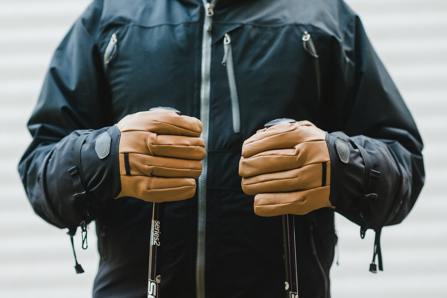 A man wearing ski gloves and holding ski poles.