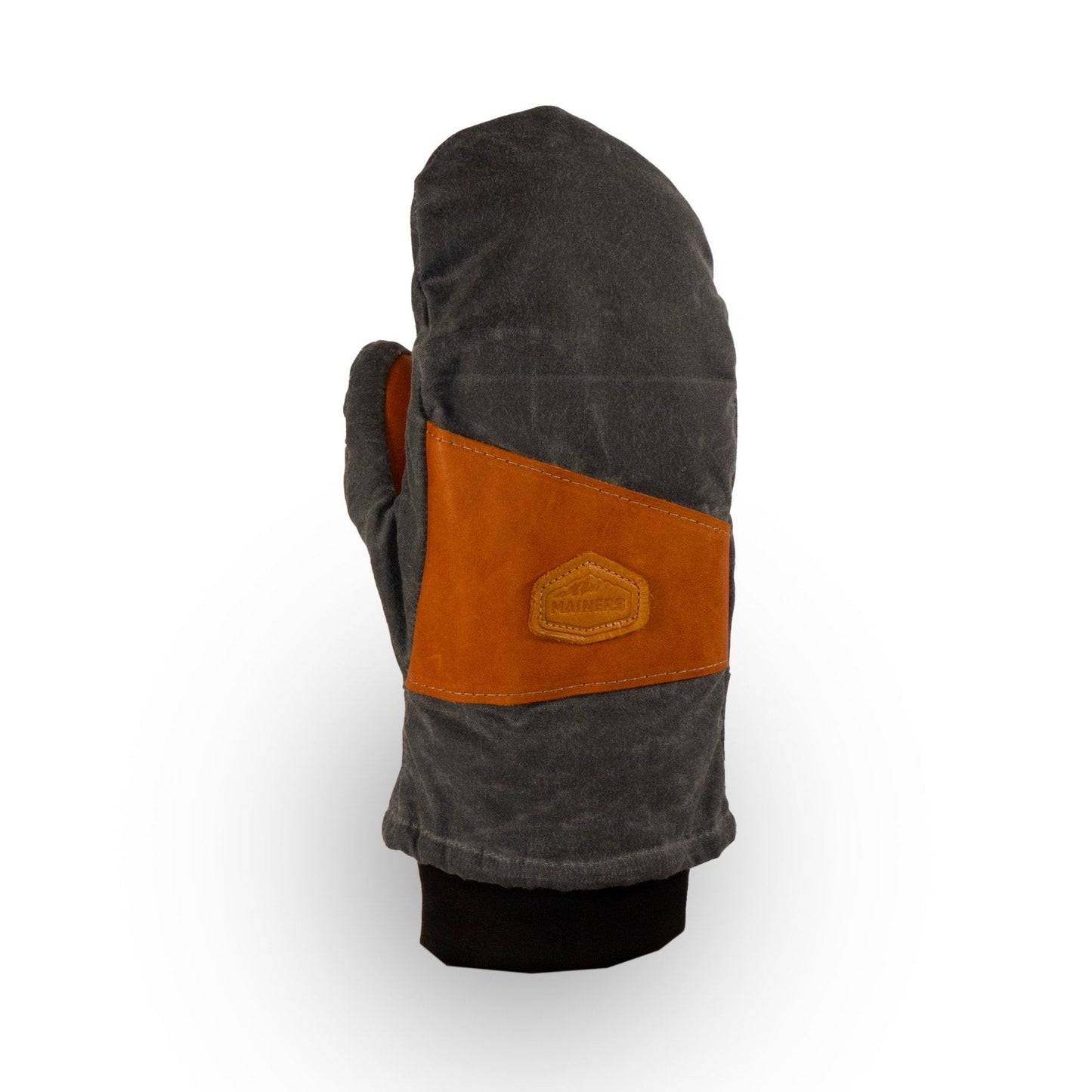 The Peaks Mitts by Mainers highlight rugged durability with a gray design and a brown leather patch logo, making them perfect for outdoor adventures. They feature a sleek black cuff for added style.