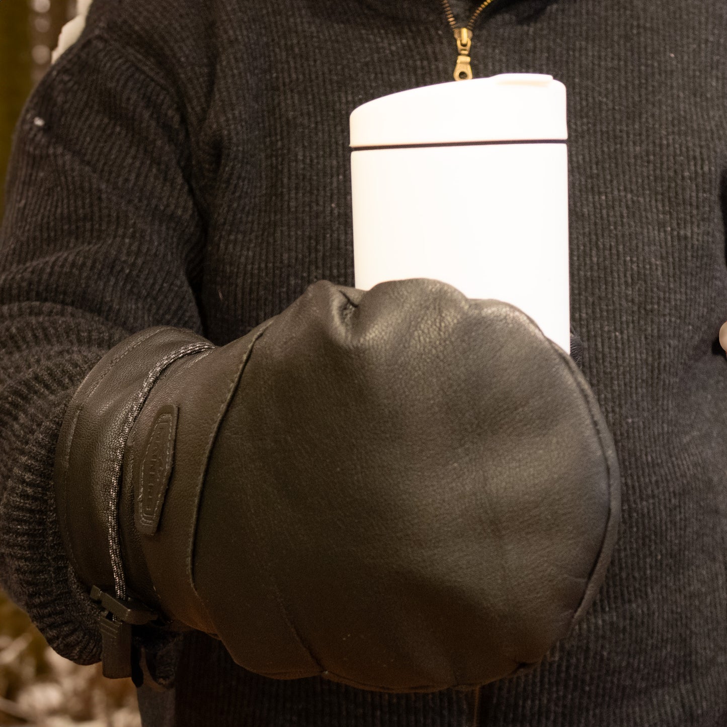 A man holding a cup of coffee in a pair of Mainers Portland Mitts with wool-fleece lining.