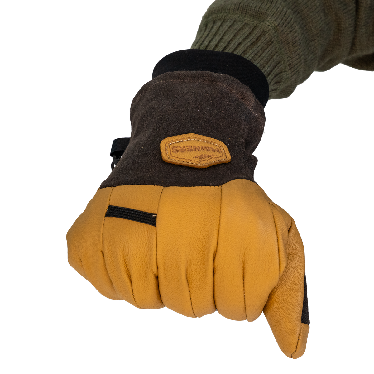 A close-up of a glove worn on a hand, showing a leather palm and back, a dark brown cuff, and a tan leather patch with the brand name 'Mainers'.