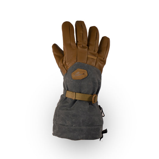 The Bethel Glove by Mainers is a single insulated glove in brown and gray, designed for cold weather adventures. It features a strap and patch on the back, while its waxed canvas construction boosts outdoor performance, guaranteeing warmth and durability in harsh conditions.