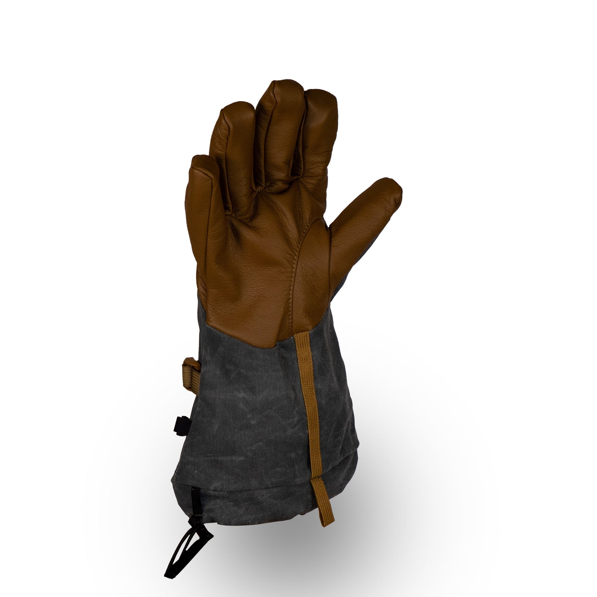 The Bethel Glove by Mainers, made from waxed canvas, is an insulated winter glove in brown and black that features a wrist strap for optimal outdoor performance. Pictured against a plain white background, these gloves effortlessly blend style and functionality.