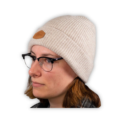 A woman wearing glasses and a Mainers Cashmere Beanie hat.