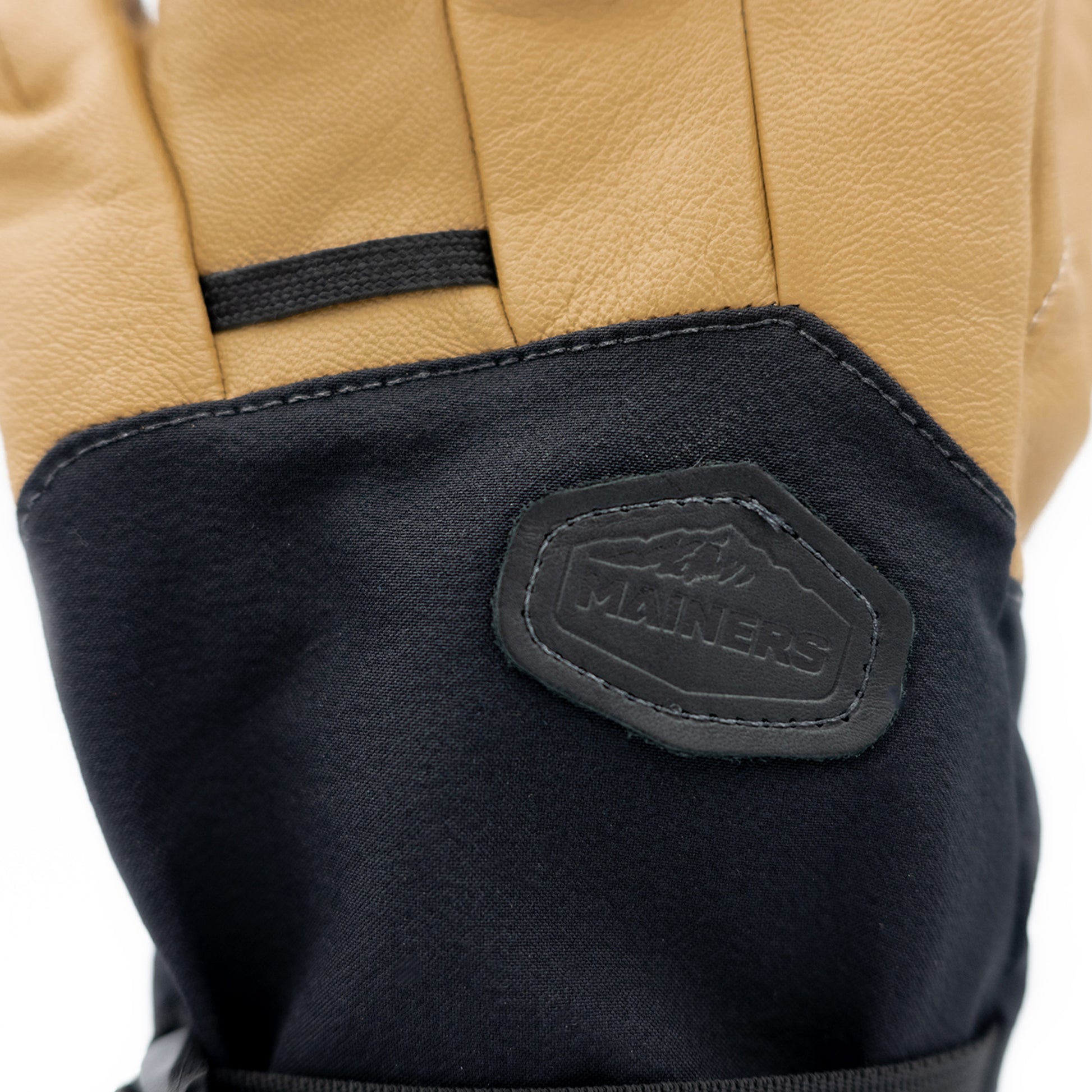 A pair of black and tan Mainers ski gloves.