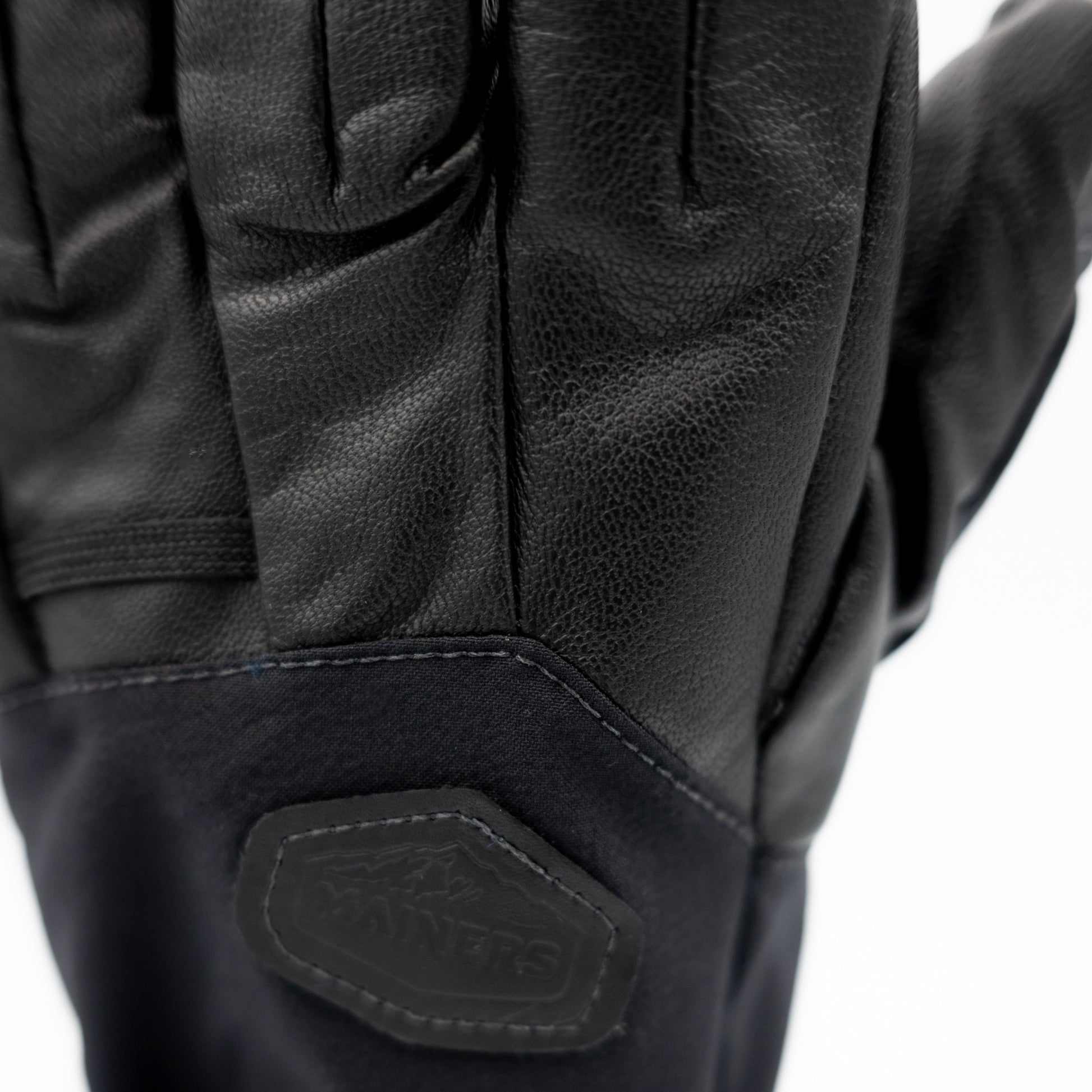 A pair of black Mainers Rangeley gloves with a logo on them.