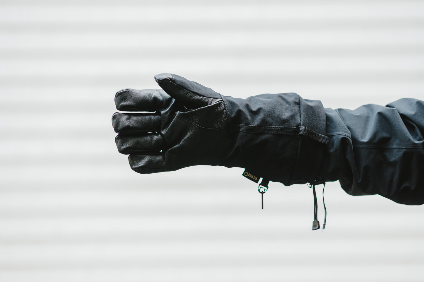 A person wearing a pair of Mainers Rangeley Gloves holding a fist.