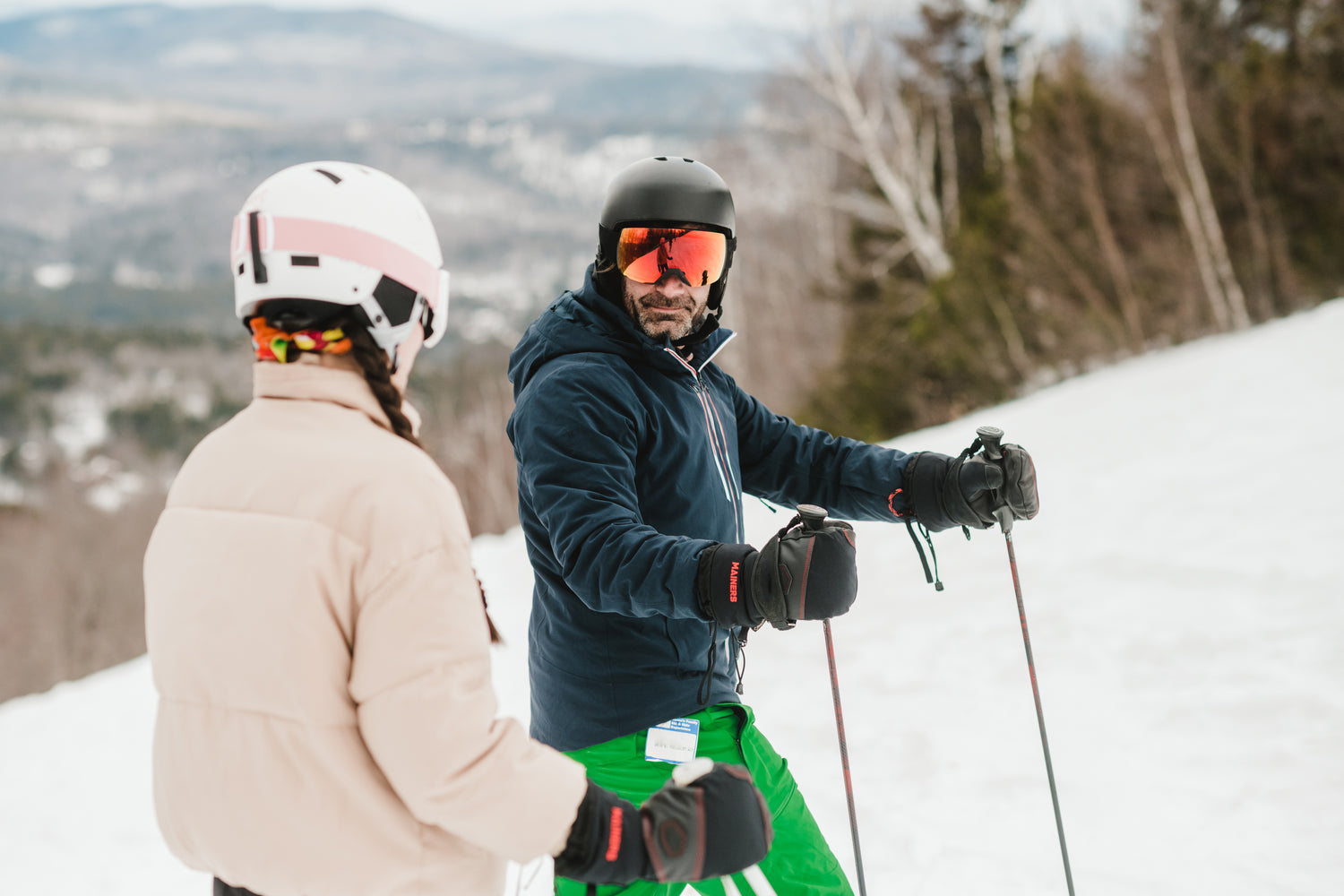 A man and woman on skis on a snowy slope.