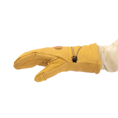 Tan mitten with a small black object on a white background