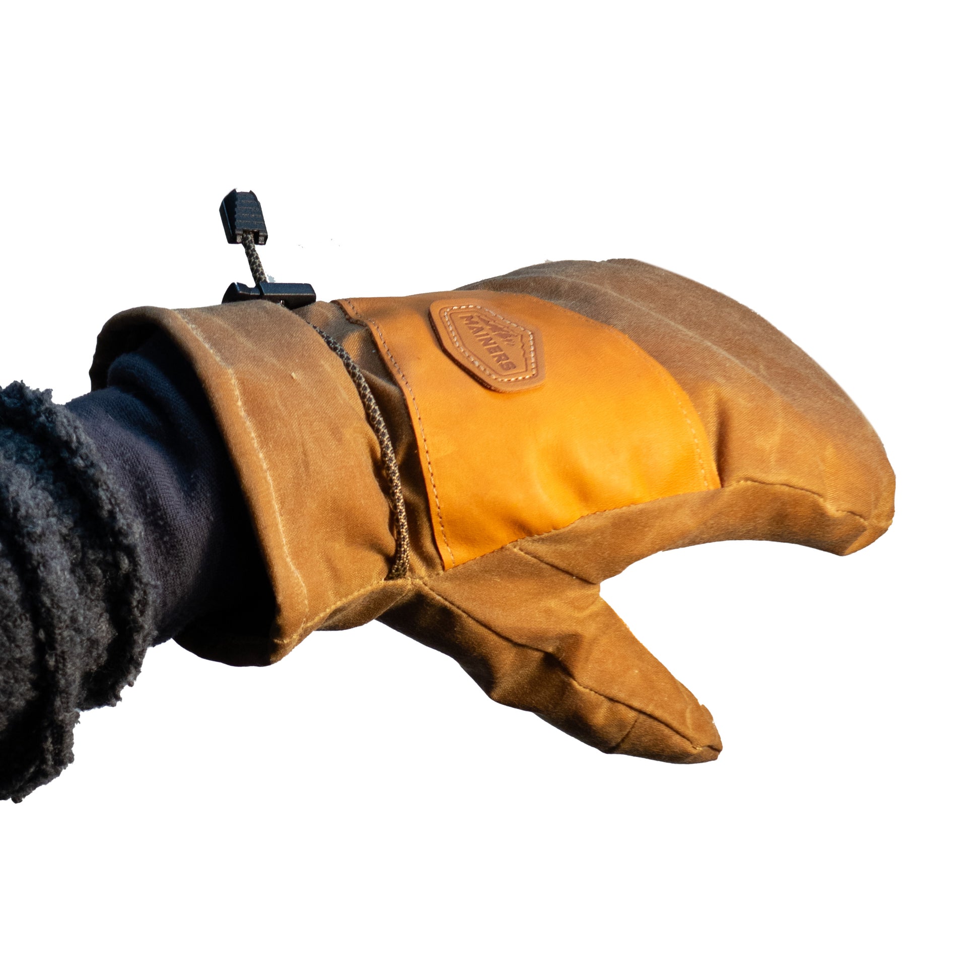 A person's hand holding a pair of Mainers Peaks Mitts.