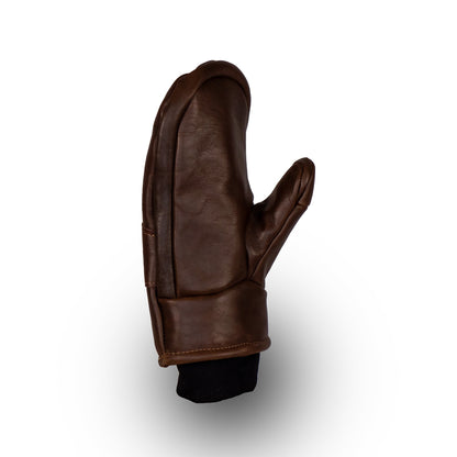 The Peaks All-Leather Mitts by Mainers, made from high-quality brown leather and featuring a stylish black cuff, are ideal for cold-weather adventures. Displayed elegantly against a white background, these mittens blend style with functionality effortlessly.