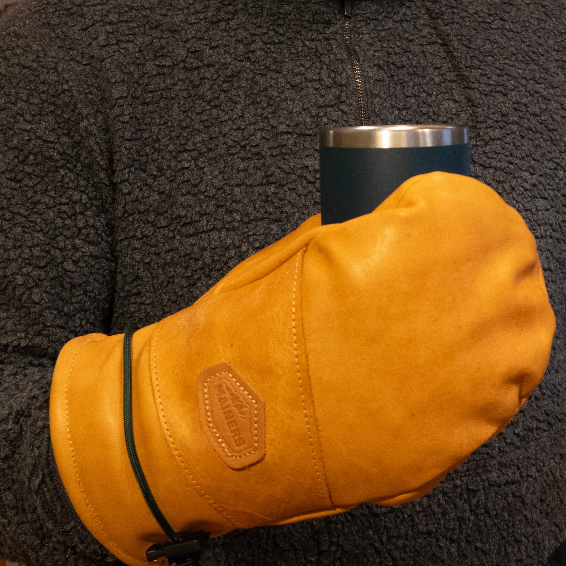 A man holding a cup of coffee in a Portland Mitts with wool-fleece lining from Mainers.