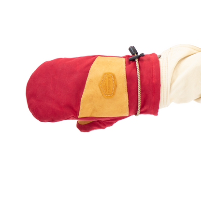 Red and tan mitten held by a hand on a white background