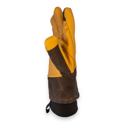A single heavy-duty leather glove shown from the side, featuring a leather back, brown waxed canvas wrist and thumb area, and a black knit cuff with a small pull tab, set against a plain white background.